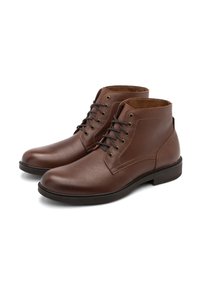 Stivaletti in pelle marrone con finitura liscia, punta arrotondata e sistema di allacciatura a cinque occhielli. Presentano una superficie texture e una suola a contrasto.