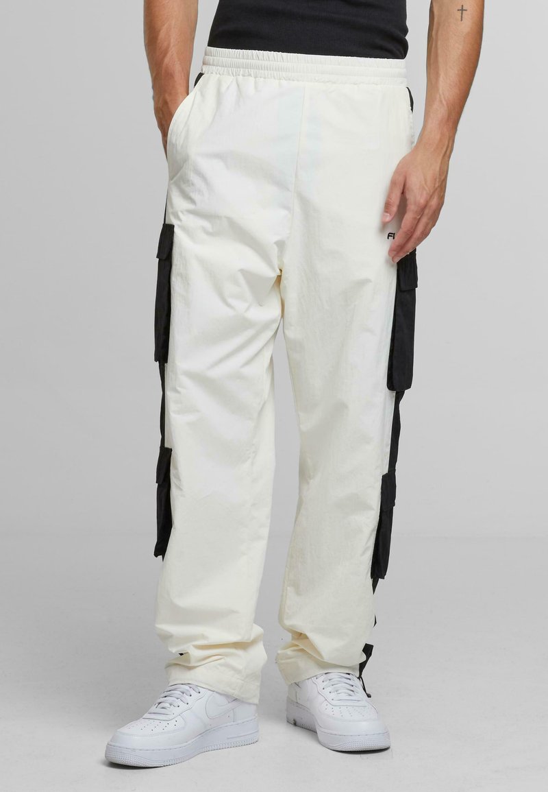 White elastic-waist cargo pants with black fabric accents and side pockets, made from lightweight material; paired with white sneakers.