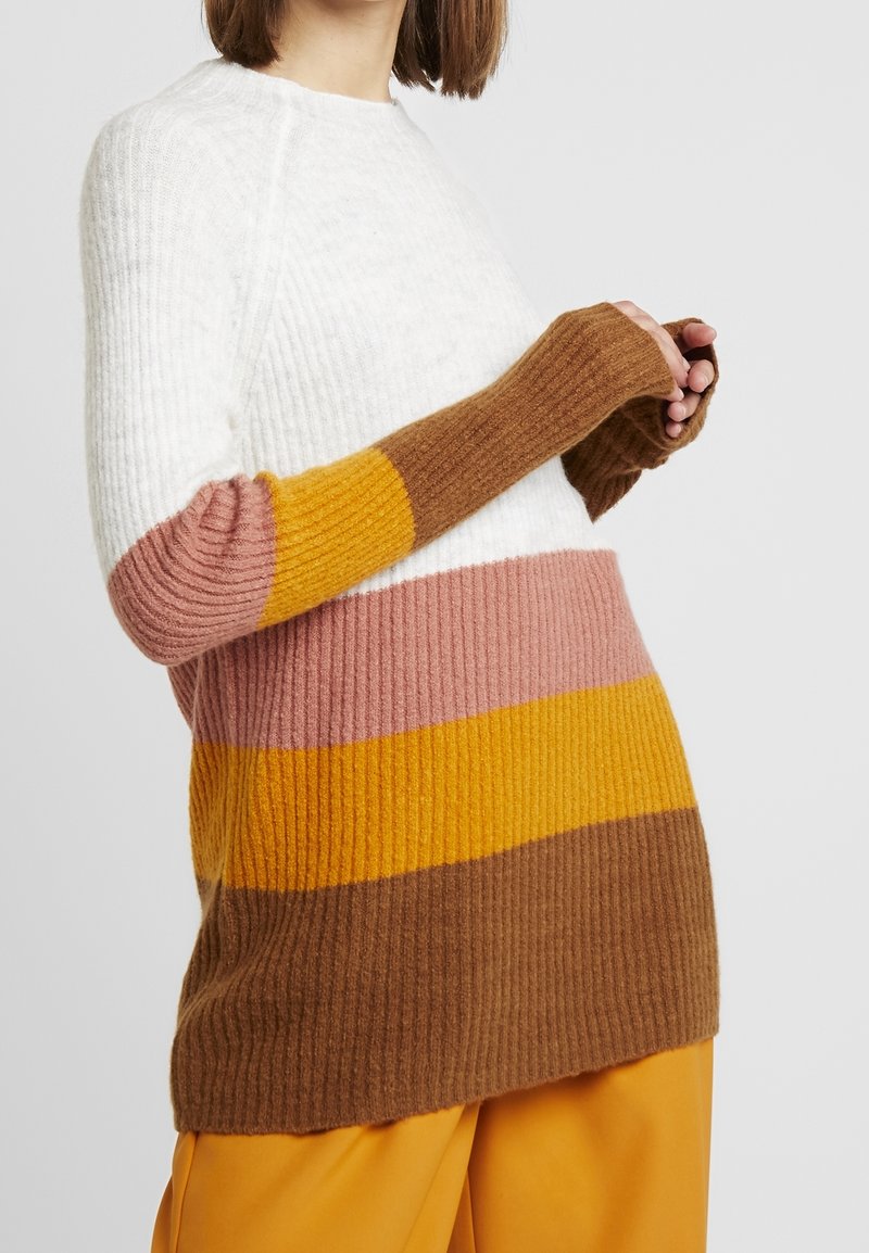 Rippstrickpullover in Weiß mit senfgelben, rosa und braunen Streifen. Mit langen Ärmeln und kontrastierenden Bündchen. Weicher Stoff.
