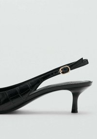 Černý lakovaný střevíček na zadním pásku s špičatou špičkou, s krokodýlím vzorem, tenkým podpatkem a zlatým přezkou.