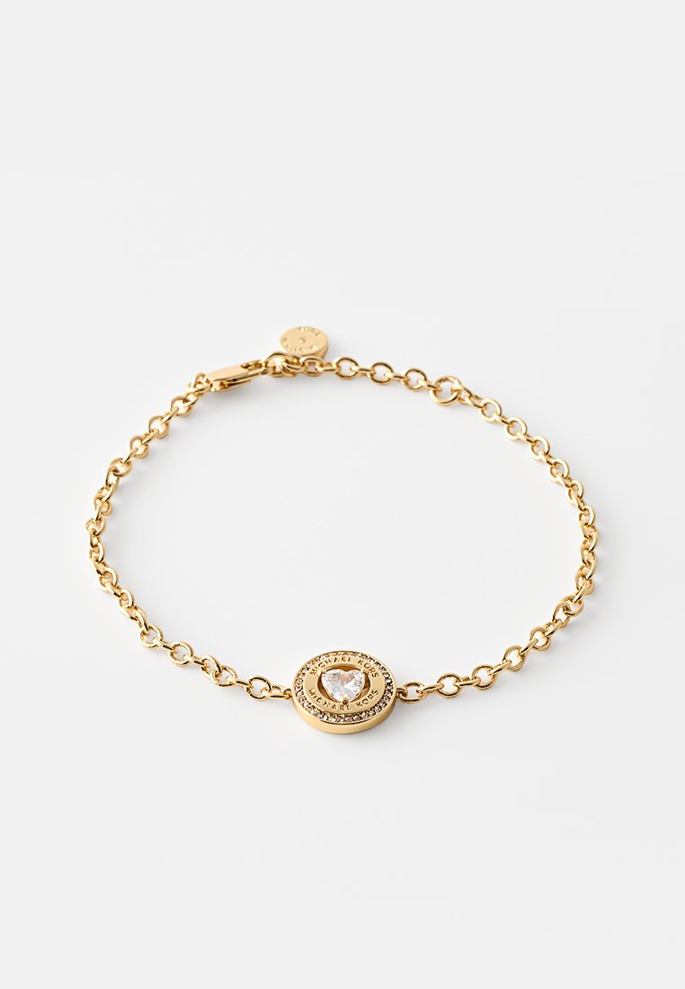 Pulsera de oro con una delicada cadena, que presenta un colgante circular adornado con una piedra central en forma de corazón y acentos circundantes.