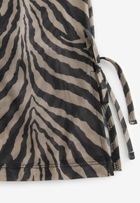 Poluprozirna tkanina s bež i crnim uzorkom zebra pruga. Ima bočne kravate i teksturirani završetak.