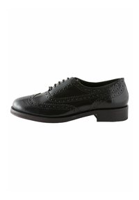 Zapato brogue de cuero negro con detalles perforados, punta redondeada, diseño con cordones y un tacón bajo cuadrado. Textura suave en todo el zapato.