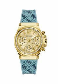 Orologio color oro con accenti di cristallo, dotato di un cinturino blu testurizzato decorato con un motivo a logo ripetuto e più quadranti per la misurazione del tempo.