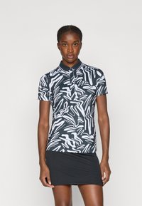 Polo preto e branco de manga curta com um padrão abstrato ondulado, com gola botão, feito de um material liso e elástico.