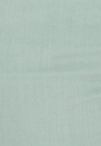 Tejido de color azul claro con una textura lisa y un sutil patrón de espiga, que presenta un color uniforme con mínimas variaciones.