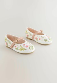 White embroidered ballet flats feature floral designs in pink, yellow, and green, with a light pink strap and a low, flat sole.