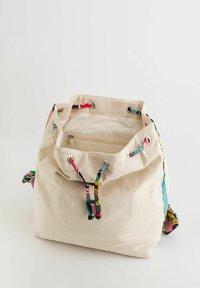 Bolsa de tela con cord�ón en beige, con acentos de patrón coloridos, que presenta ojales y cordones en diseños rosa, azul y multicolor.