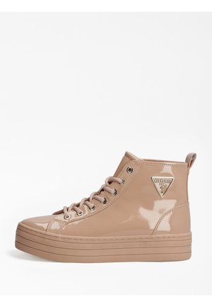 Beige hoge sneaker van lakleer met plateauzool, veters en metalen Guess-logo aan de zijkant.