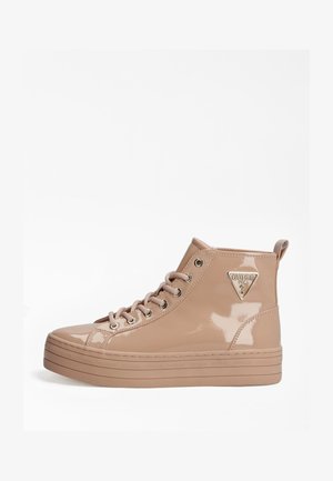Baskets montantes en cuir verni beige avec semelle plateforme, lacets et logo métallique Guess sur le côté.
