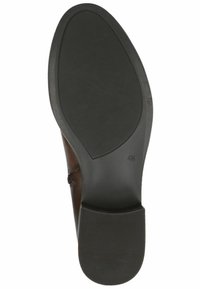 Semelle de chaussure en cuir marron avec une finition lisse, une forme arrondie, et des motifs de grip texturés avec un léger talon et des surpiqûres sur les côtés.