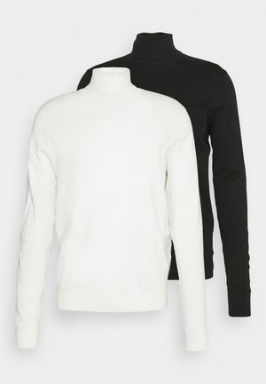 Deux pulls à col roulé à manches longues ; un blanc et un noir. Les deux ont une texture douce et un design ajusté, avec des cols hauts et des poignets côtelés.