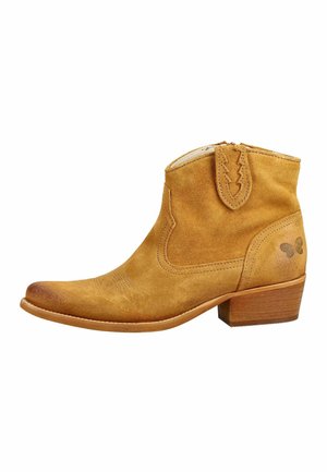 Bottine en daim camel avec talon bloc en bois, coutures décoratives, languette de tirage et logo papillon à l'arrière.