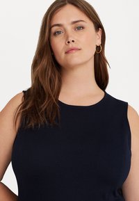 Navy blue sleeveless top with a rounded neckline, made of smooth fabric. Features subtle seams and a fitted design.