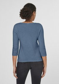 Blauer Pullover mit mittellangen Ärmeln und rundem Ausschnitt. Weiche Stricktextur, lockere Passform und flacher Saum. Trägt man mit dunklen Jeans.