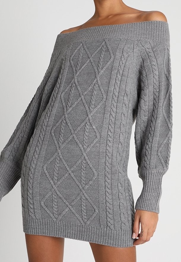 Femme portant une robe pull en maille torsadée grise, à épaules dénudées, manches longues, avec poignets, ourlet et encolure côtelés.
