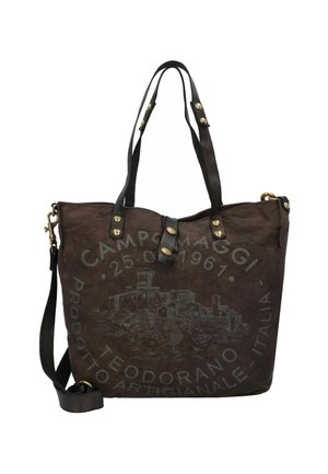Borsa tote in tela marrone con manici in pelle nera, con hardware dorato e un design a rilievo di un castello e dettagli testuali.