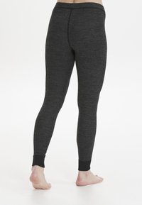 Mörkgrå leggings i ett texturerat tyg, med en figurnära passform och ankelfållar. Midjan är elastisk för komfort.