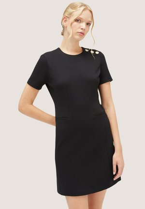 Robe noire à manches courtes avec une coupe ajustée, dotée de deux poches latérales et de détails décoratifs en boutons sur l'épaule. Texture de tissu lisse.