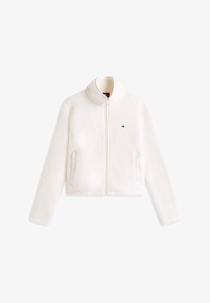 Biała kurtka z polaru z wysokim kołnierzem, przednim zamkiem błyskawicznym i bocznymi kieszeniami. Posiada małe logo na piersi. Miękka tekstura, krótki krój.
