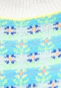 Maglione lavorato a maglia con scollo bianco e motivo multicolore che presenta disegni floreali blu, verdi e arancioni su uno sfondo chiaro.