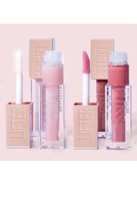 Drie lipgloss-tubes: doorzichtige containers met beige doppen. Eén gloss is wit, de andere lichtroze en de derde heeft een diepere rozenkleur.