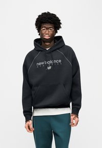 Zwarte hoodie met voorzak, voorzien van de opdruk "new balance ATHLETICS". Gladde textuur, geribbelde manchetten en capuchon met trekkoord.
