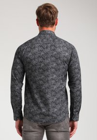 Camicia a maniche lunghe in tessuto grigio scuro con un intricato motivo nero. Collo classico, polsini con bottoni e design dell'orlo curvo.