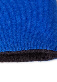 Tessuto blu lavorato a maglia con una superficie texture, che transita verso un bordo nero uniforme. Il materiale sembra morbido e flessibile.