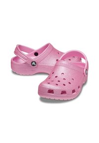 Różowe cekinowe klapki z otworami wentylacyjnymi, tylnym paskiem i okrągłym logo z boku. Wykonane z lekkiego materiału syntetycznego.