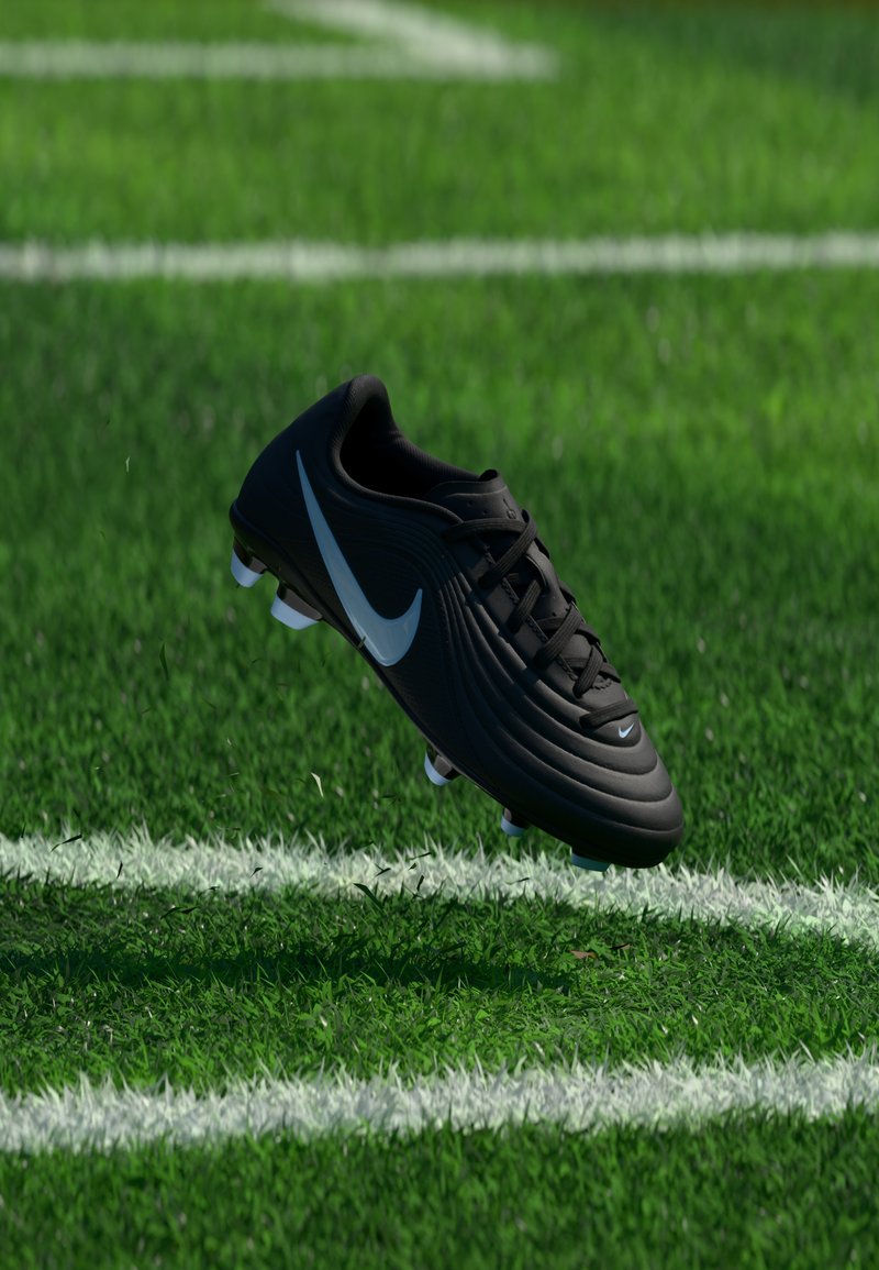 Μαύρο ποδοσφαιρικό παπούτσι Nike με λευκό λογότυπο Swoosh να αιωρείται πάνω από πράσινο γήπεδο με λευκές γραμμές.