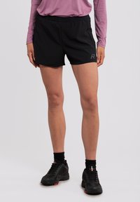 Shorts sportivi neri con vita elastica, tessuto morbido e tasche laterali. Presentano un logo riflettente sulla parte inferiore della gamba sinistra.