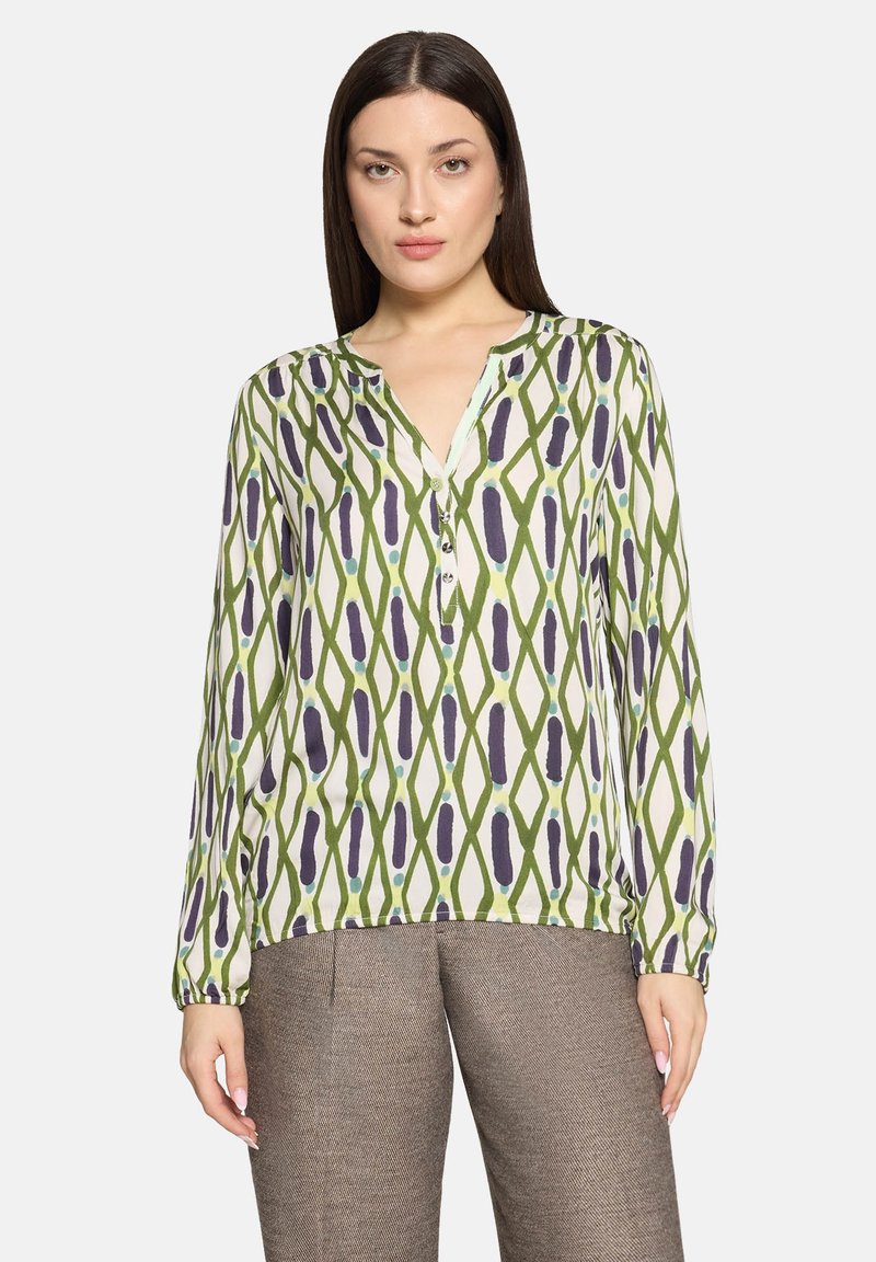 Bluzka z długim rękawem w zielono-białym kolorze, ozdobiona wzorem diamentowym z fioletowymi akcentami, z dekoltem w kształcie litery V i listwą z guzikami. Lekka tkanina.
