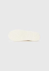 Semelle de chaussure en caoutchouc blanc avec des motifs texturés et des rainures pour une meilleure adhérence, avec un bord lisse et une finition soignée.