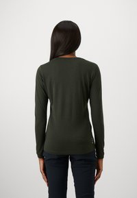 Long-sleeve top in dark green fabric, featuring a round neckline and fitted design. Smooth texture with minimal seams and no visible patterns.