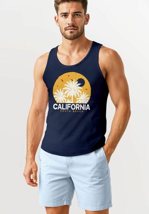 Marinefarbener Tank-Top mit gelbem kreisförmigem Grafikdesign, das Palmen und den Text "CALIFORNIA SOUTH BEACH" zeigt, kombiniert mit hellblauen Shorts.