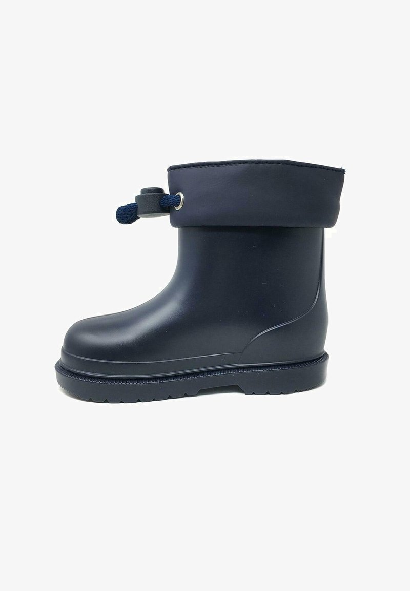 Botín de goma negro hasta el tobillo con un puño doblado, que presenta un cierre de cordón y una suela texturizada para mayor tracción. Superficie lisa, material duradero.