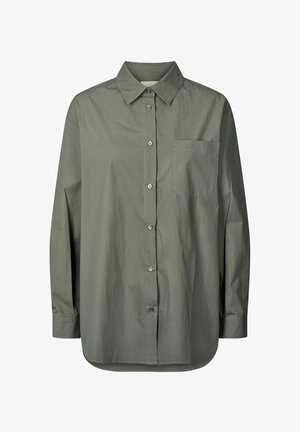 Košulja s dugim rukavima u maslinastoj boji, izrađena od glatkog materijala. Ima ovratnik, dugih rukava, džep na prsima i zaobljen rub.