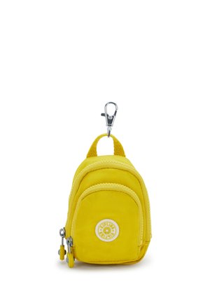 Porte-clés mini sac à dos en tissu jaune avec poche avant, fermetures éclair et clip métallique pour fixation.