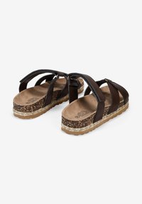 Sandales à plateforme marron avec plusieurs sangles croisées, semelle en liège, semelle texturée et semelle intérieure lisse. Détail de boucle ajustable sur le côté.
