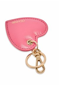 Różowy brelok do kluczy w kształcie serca wykonany ze skóry, z dodatkami ze złotego metalu i detalami przeszyć, wyposażony w kółko do kluczy dla bezpiecznego przypięcia.