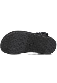 Suela de sandalia de goma negra con un patrón texturizado de formas de diamante y el logotipo "Teva". Duradera y diseñada para ofrecer tracción.