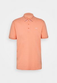 Lyhythihainen polo-paita vaalean persikan värisestä puuvillasta. Ominaisuuksina kaksinappinen kaulus, kontrastiväriset valkoinen ja punainen kaulus sekä hienovarainen logotunnus.