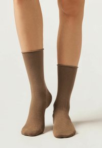 Braune Socken mit glatter Oberfläche, mittellang bis zur Wade und elastischem Bund. Weiches Material in einfarbiger Optik ohne sichtbare Muster oder Hardware.