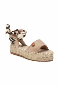 Sandalía tipo cuña de esparto beige con parte superior de suave ante, punta abierta, plataforma de yute trenzado y un lazo en el tobillo de tela con patrón.