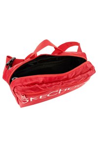 Bolso de cintura de tela roja con cierre de cremallera, interior negro y correas ajustables. Cuenta con un logotipo frontal y múltiples compartimentos para almacenamiento.
