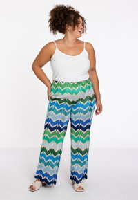 Wijde broek met een zigzagpatroon in groen, blauw en beige. Gemaakt van een lichte stof met een relaxte pasvorm.