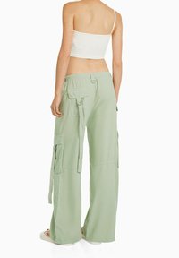 Gröna vida cargobyxor i lätt tyg, med flera fickor och ett elastiskt midjeband för komfort.