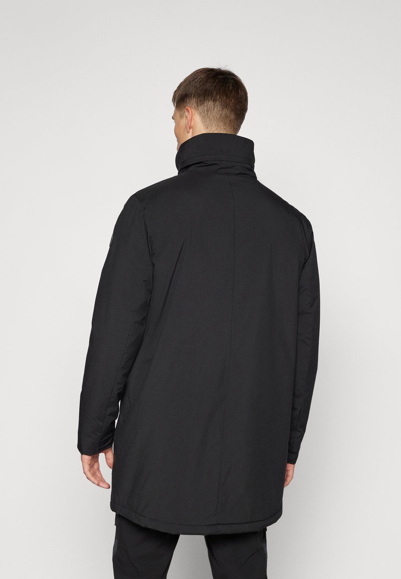 Czarny długi płaszcz z wysokim kołnierzem, wykonany z gładkiego, teksturowanego materiału, charakteryzujący się prostym krojem i brakiem widocznych elementów metalowych lub wzorów.