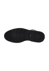 Semelle de chaussure en caoutchouc noir présentant un motif de semelle multidirectionnel avec des crampons circulaires et rectangulaires pour une adhérence et une traction optimales.